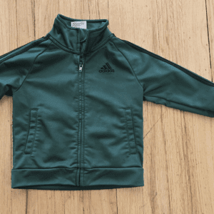 Dark green zip-up jacket laid flat on wooden surface.