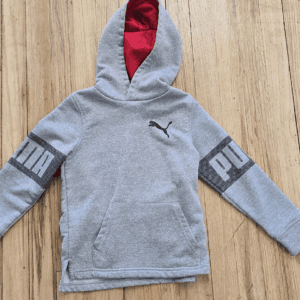 Gray Puma hoodie with red inner hood lining on a wooden surface.