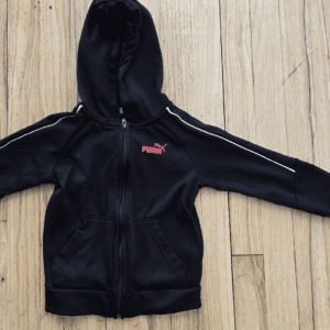 Black zip-up hoodie with a Puma logo on a wooden surface.