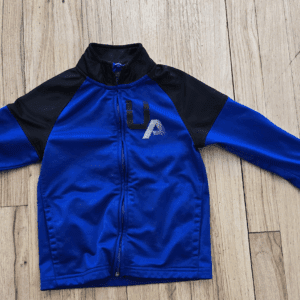 Blue and black long-sleeve jacket with a zipper on a wooden floor.