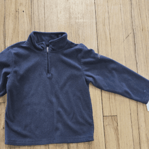 Navy blue fleece pullover with quarter-zip on wooden floor.