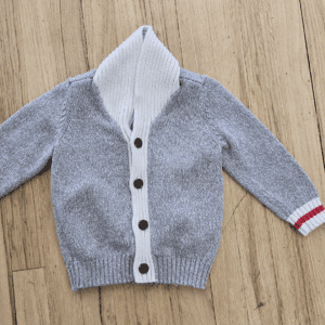 Gray knitted baby cardigan with hood and buttons.