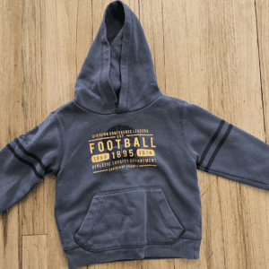 Gray children's hoodie with football-themed print on wooden floor.