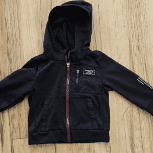 Black zip-up hooded jacket with red accents and logo patches.