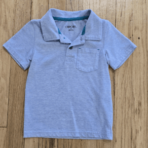 Light blue short-sleeve polo shirt on wooden surface.