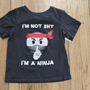Black t-shirt with a ninja graphic and bold text.