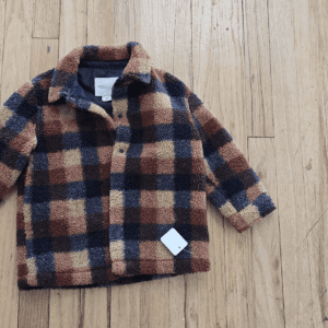 Checkered wool jacket with a pocket on wooden floor.